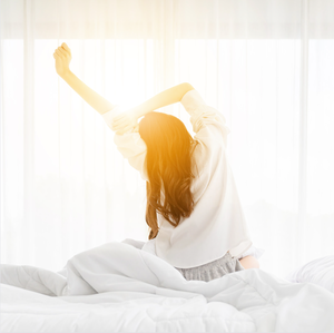 Woman waking up and stretching after getting enough rest. 